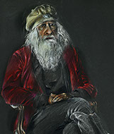 Seated portrait of a bearded man wearing riding boots.