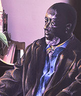 Portrait of seated older man beside upright piano.